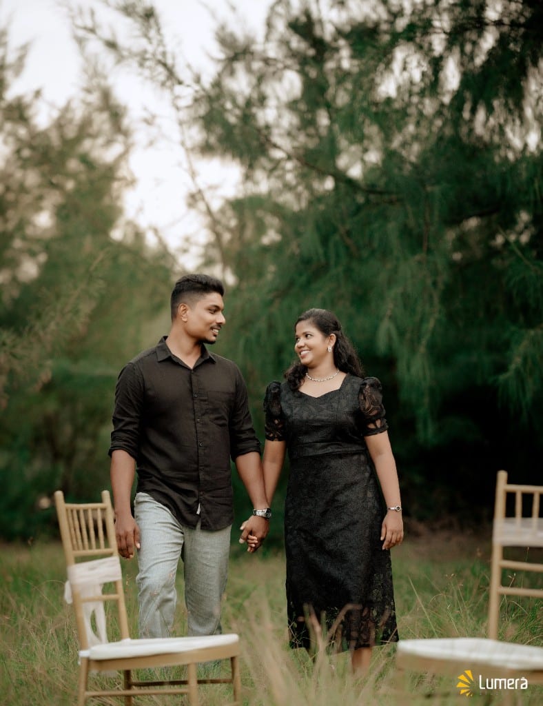 Couple holding hands during an outdoor photoshoot among the trees, photographed by Lumera Studio
