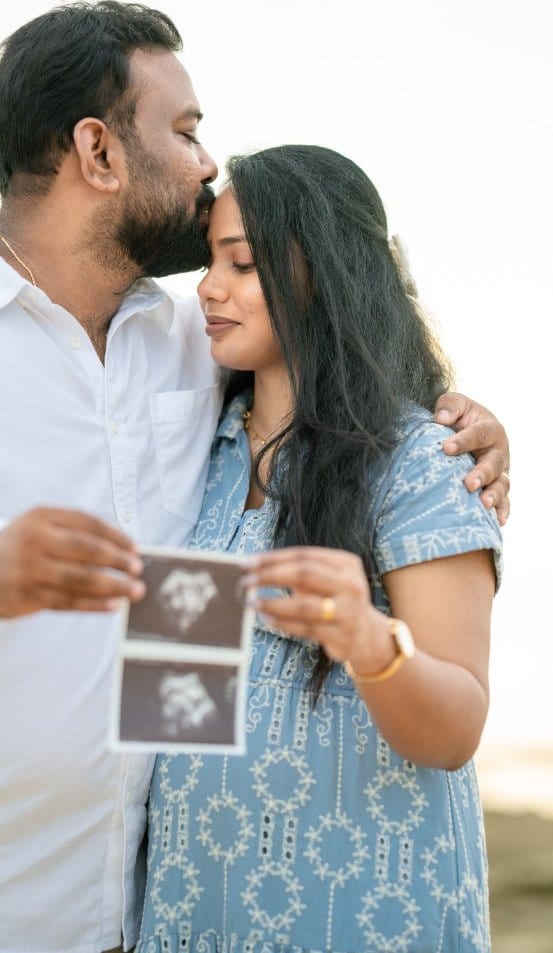 Couple holding ultrasound photographs during a pregnancy photoshoot, photographed by Lumera Studio